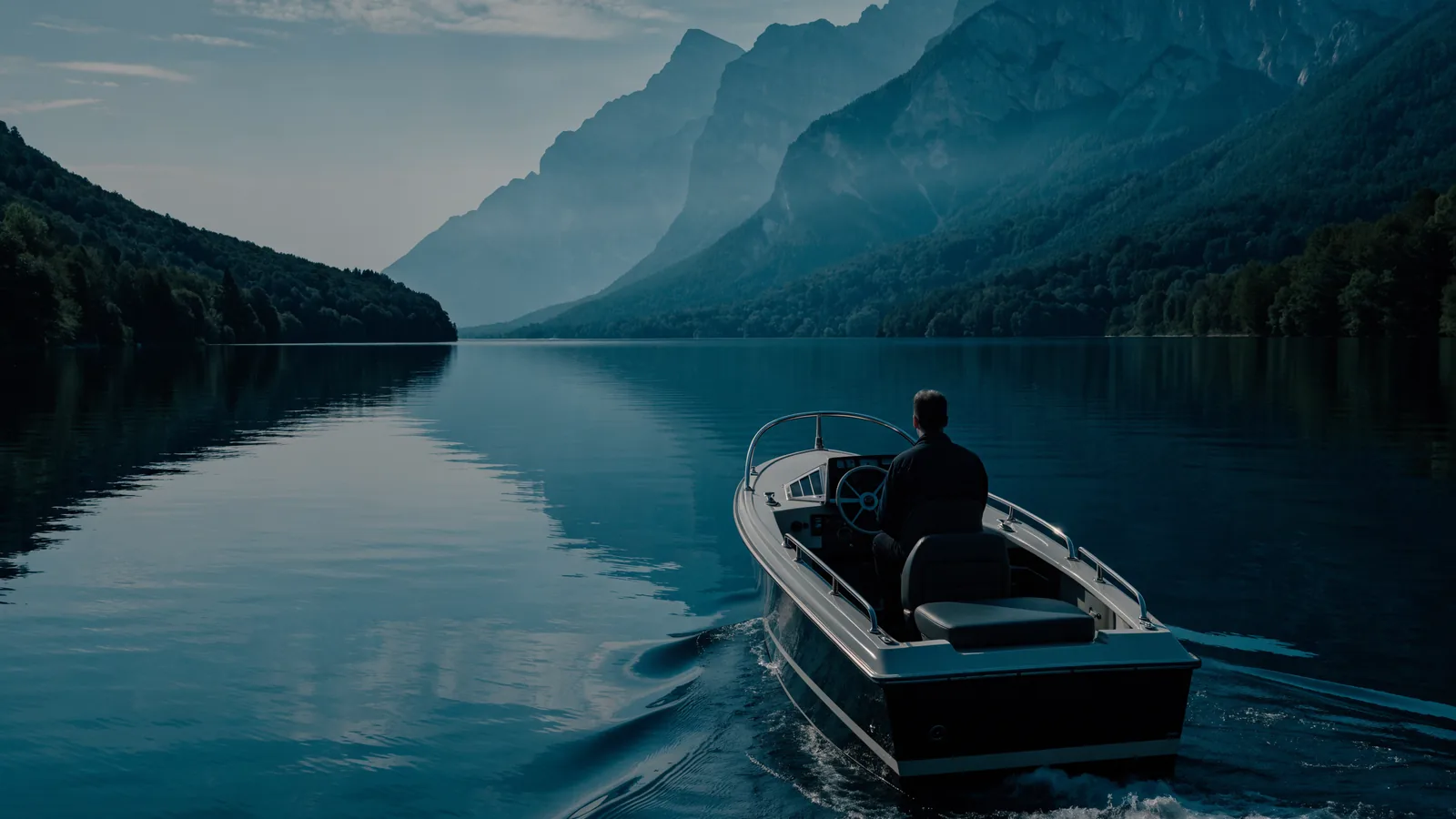 Motorboot auf einem Alpensee mit Bergen im Hintergrund