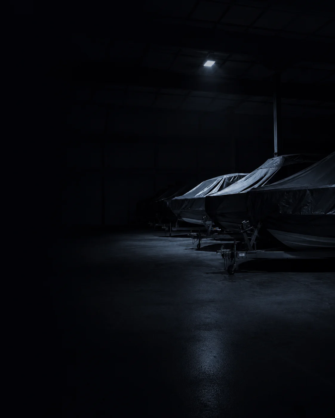 Boote unter Persenning im dunklen Lager