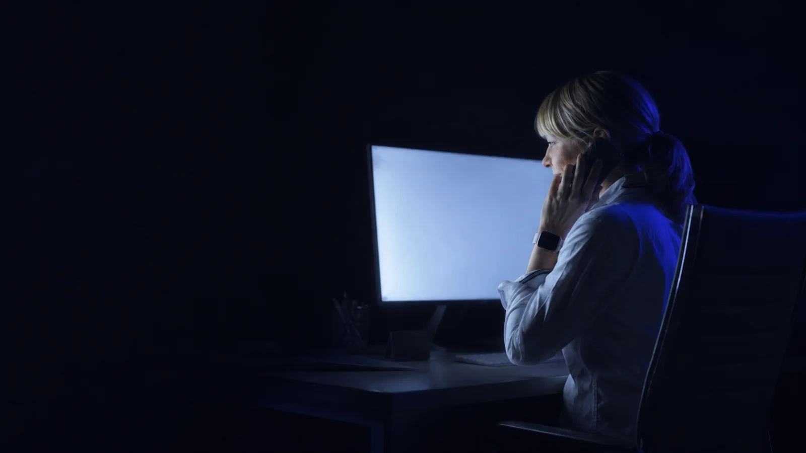 Mitarbeiterin der NAMMERT-Schadenabteilung am Telefon, Büro am Abend