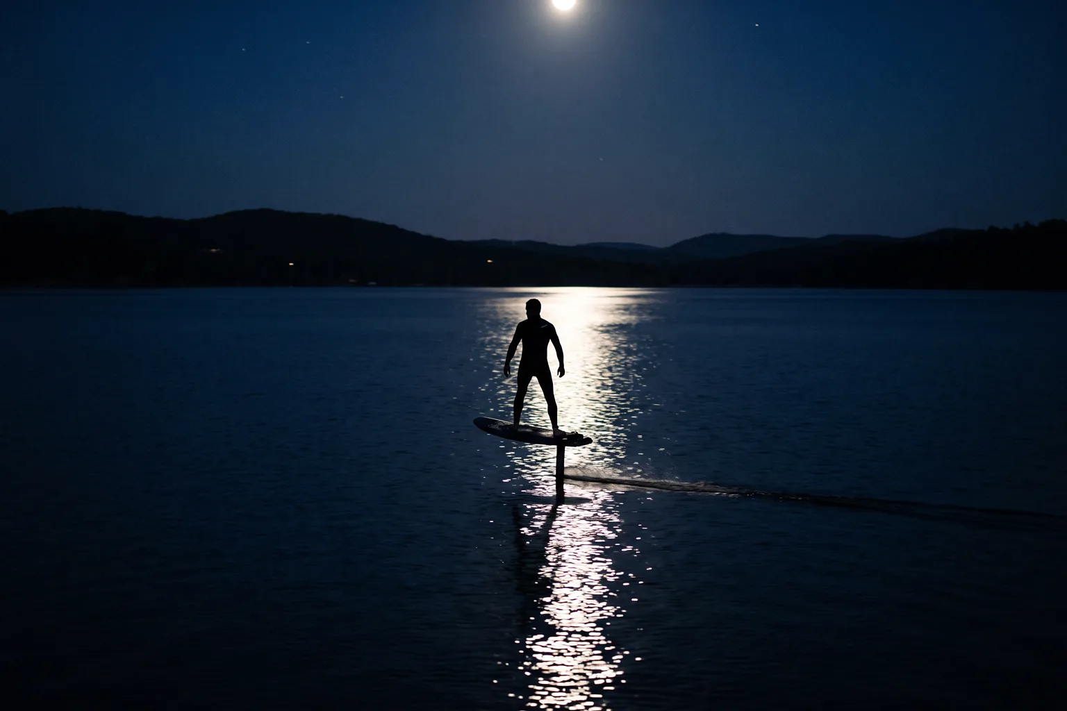 E-Foil bei Nacht, Fahrer über dem Wasser im Mondlicht