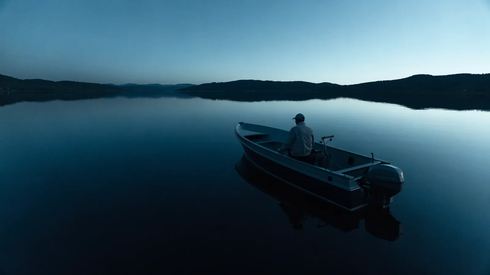 Elektroboot auf spiegelglattem See am Abend