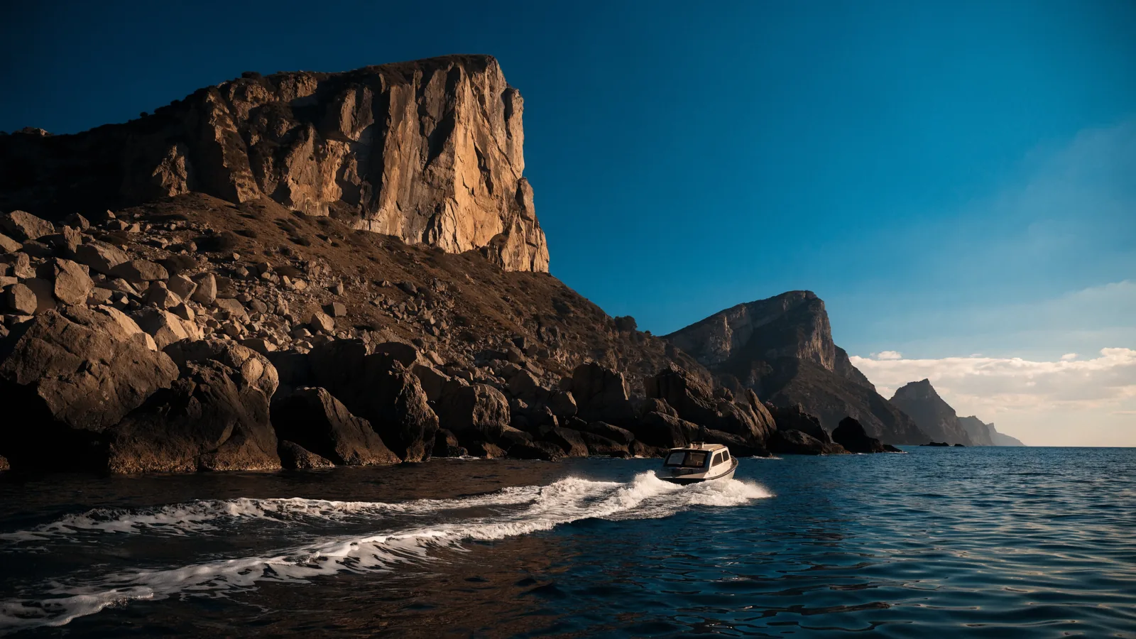 Felsküste in Spanien mit einem Boot nah unter Land