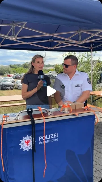 Beamter der Wasserschutzpolizei Brandenburg im Gespräch an einem Graviertisch im Freien