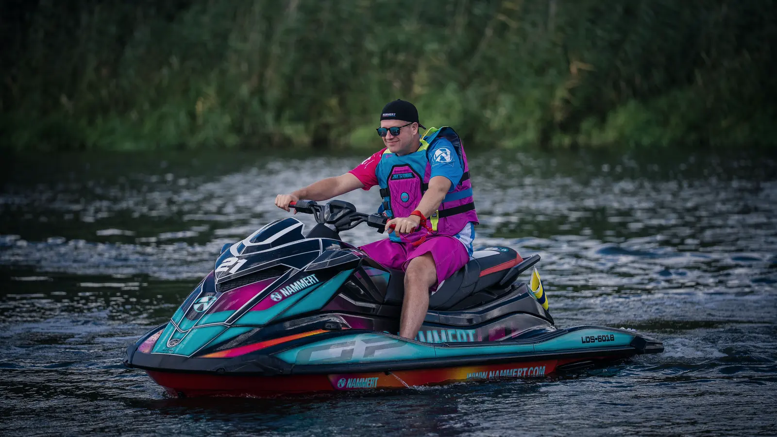 Jetski in Fahrt auf der Havel, Fahrer in Schwimmweste, Schilfufer im Hintergrund