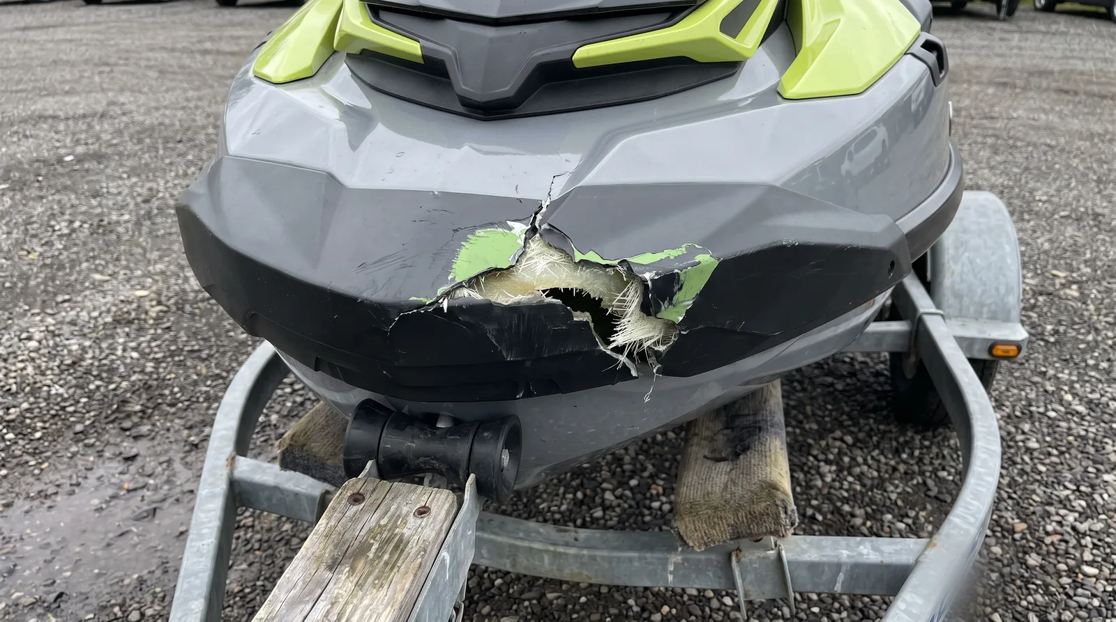 Bug eines grauen Jetskis auf dem Trailer mit aufgerissenem Rumpf nach einem Anprall.