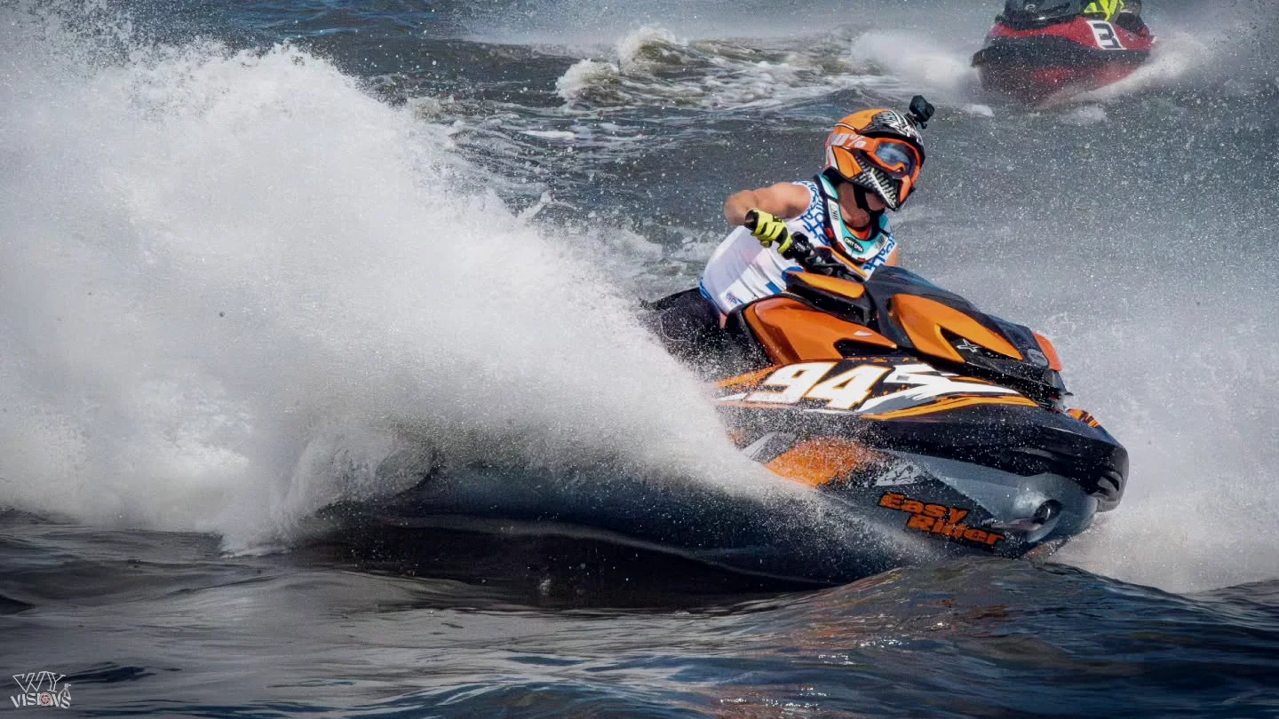 Justin P. mit der 94 in voller Schräglage beim Grand Prix in Vichy, orange Helm, Gischtwand hinter ihm