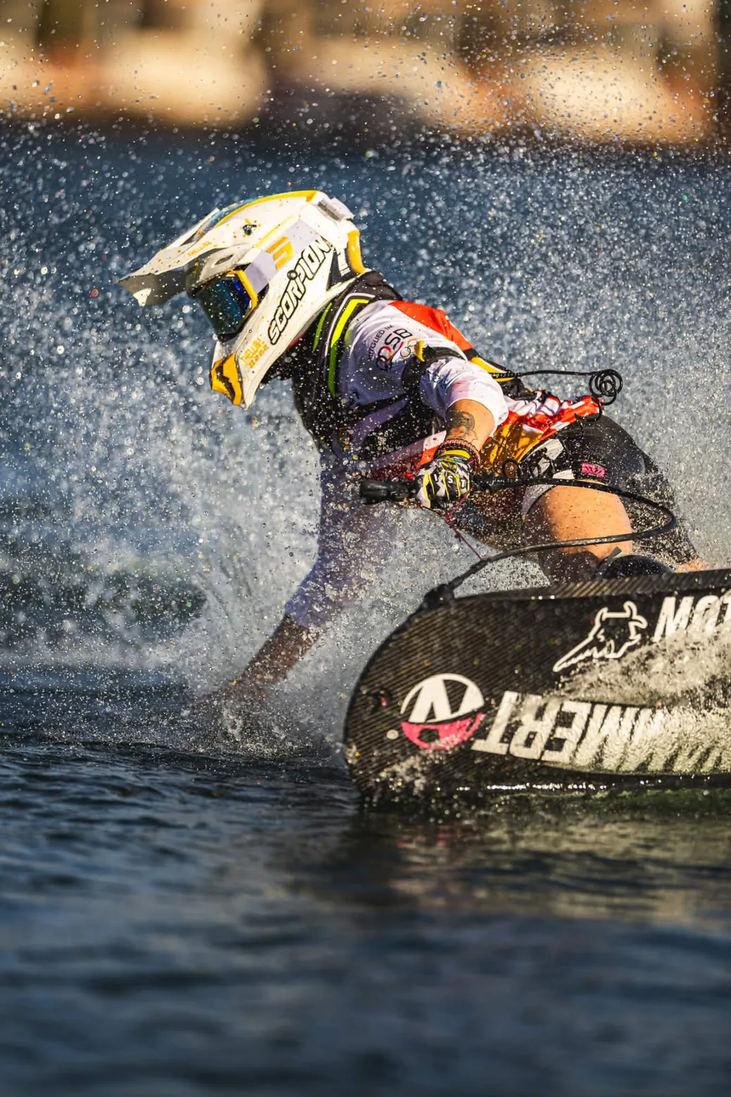 Laureen Thellin Deprez in a hard turn, board and rider almost horizontal in the spray