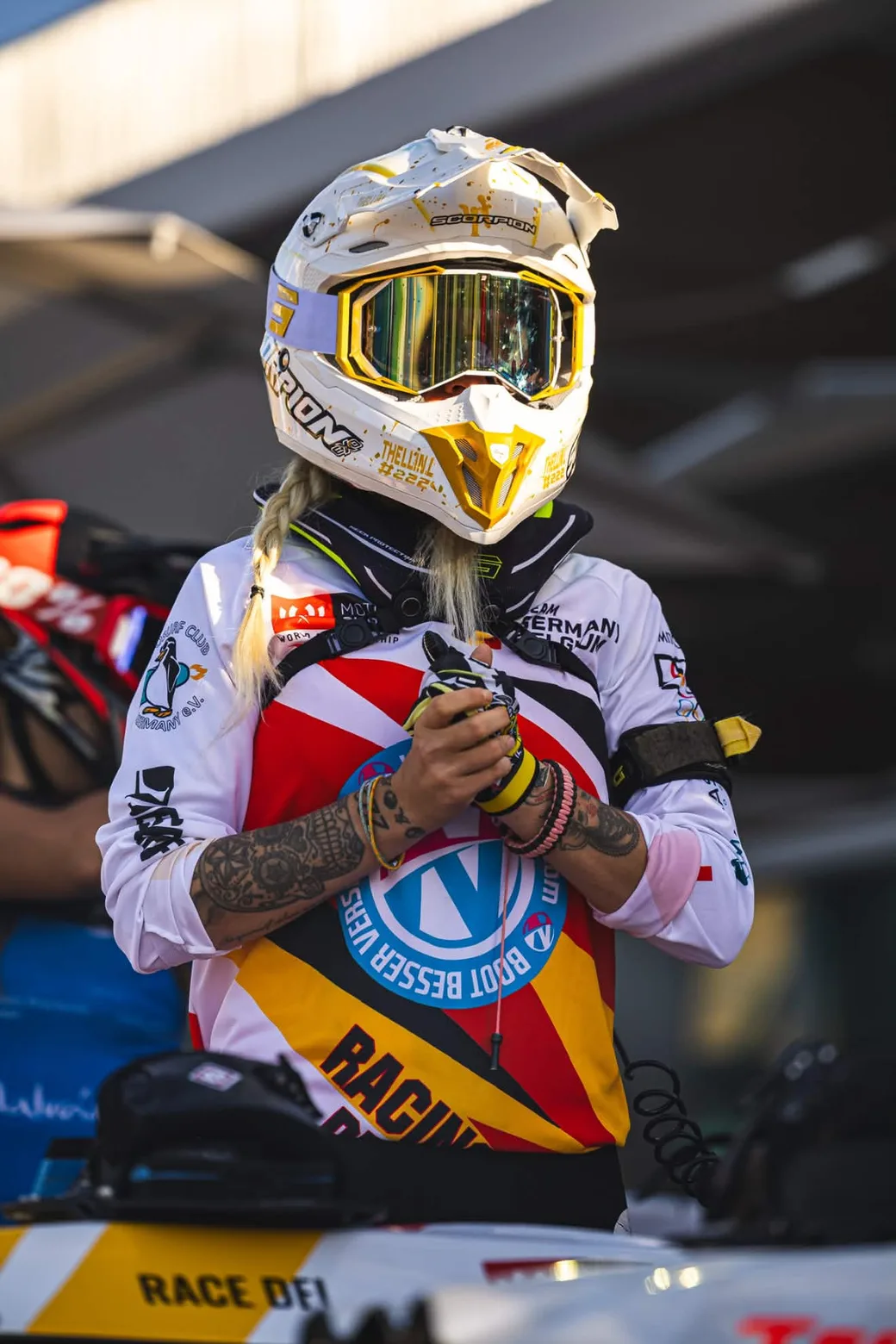 Laureen Thellin Deprez at the start area, helmet on, gloves in hand, plait over her shoulder