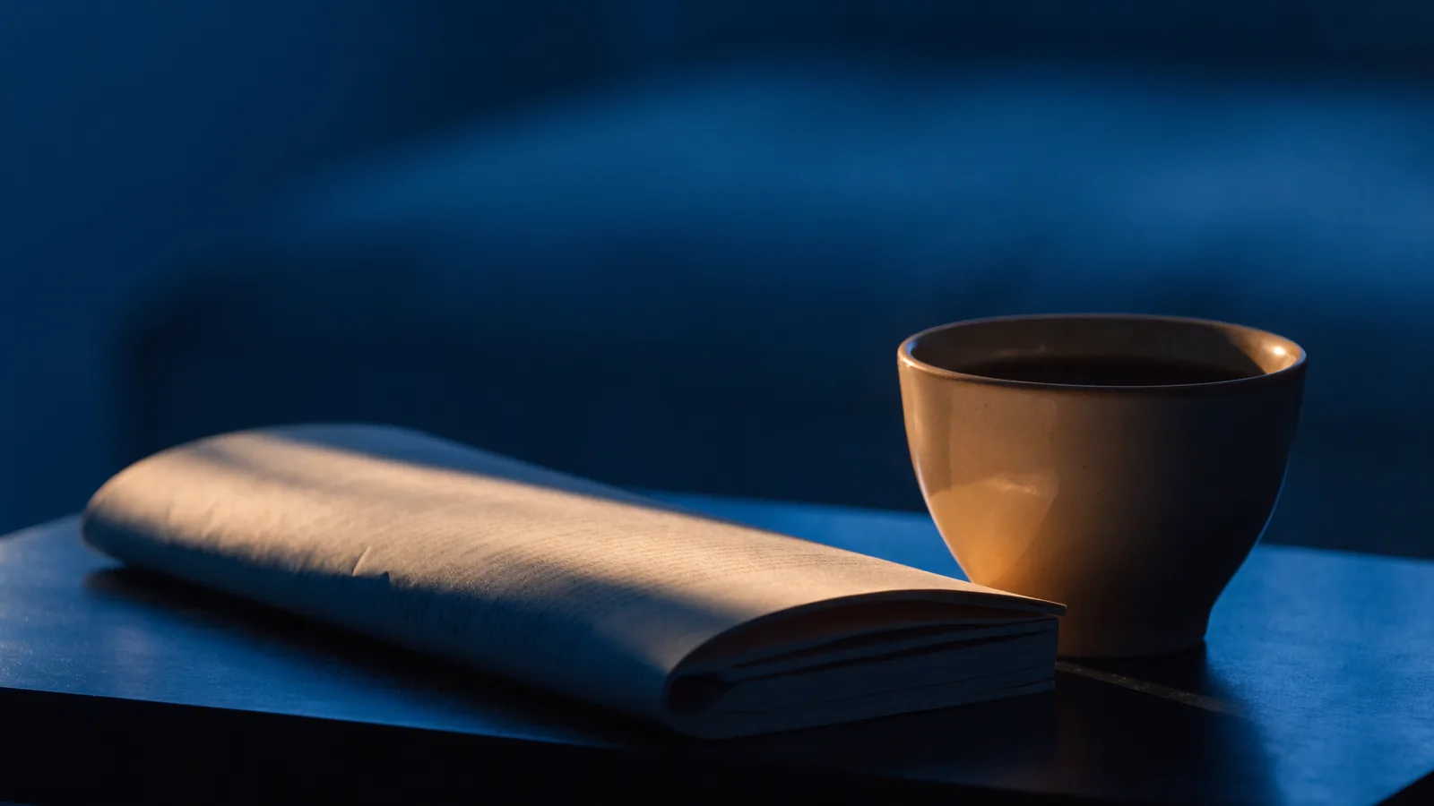 Zusammengefaltete Zeitschrift neben einer Tasse
