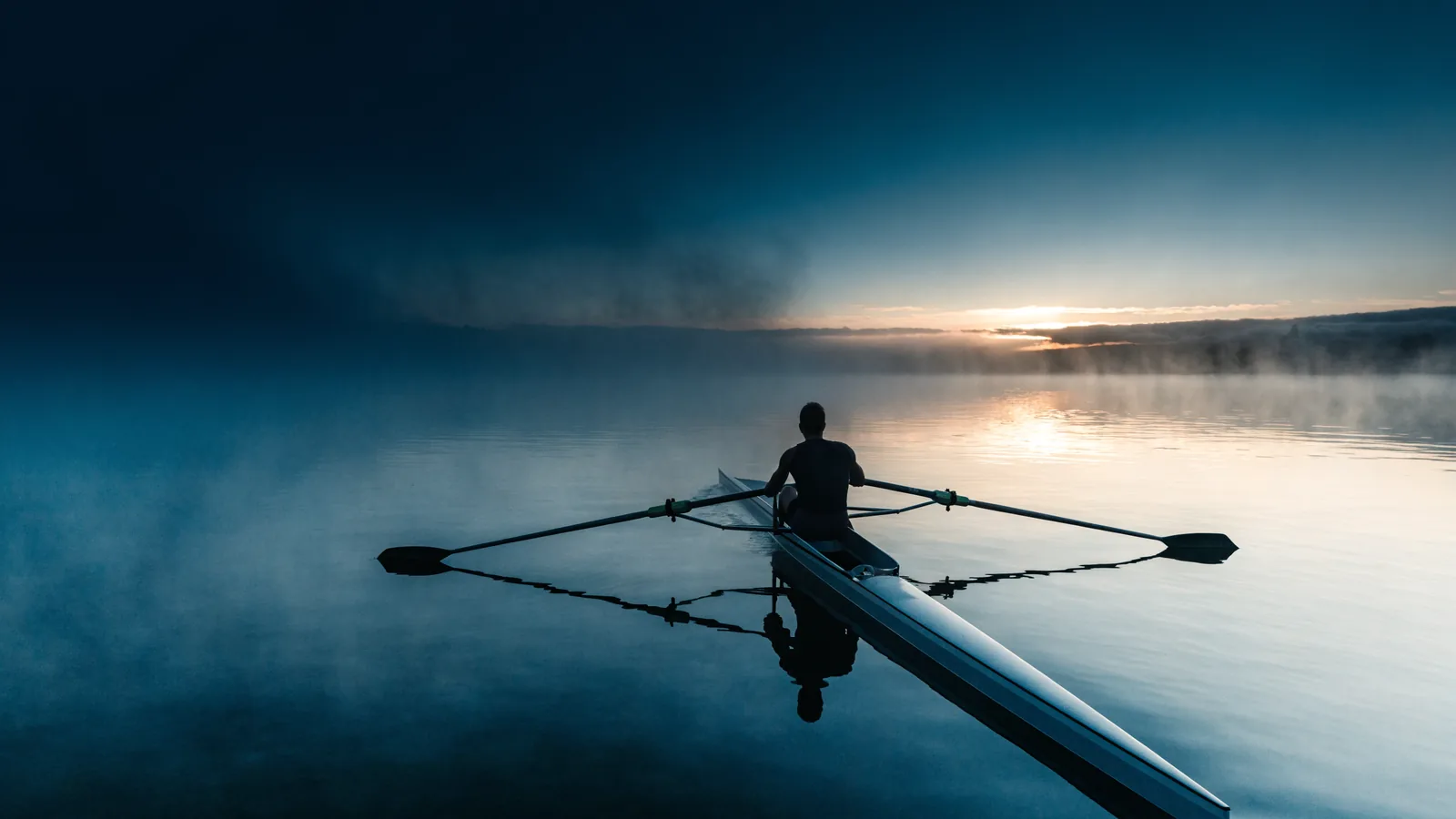 Ruderboot auf ruhigem Wasser bei Sonnenaufgang
