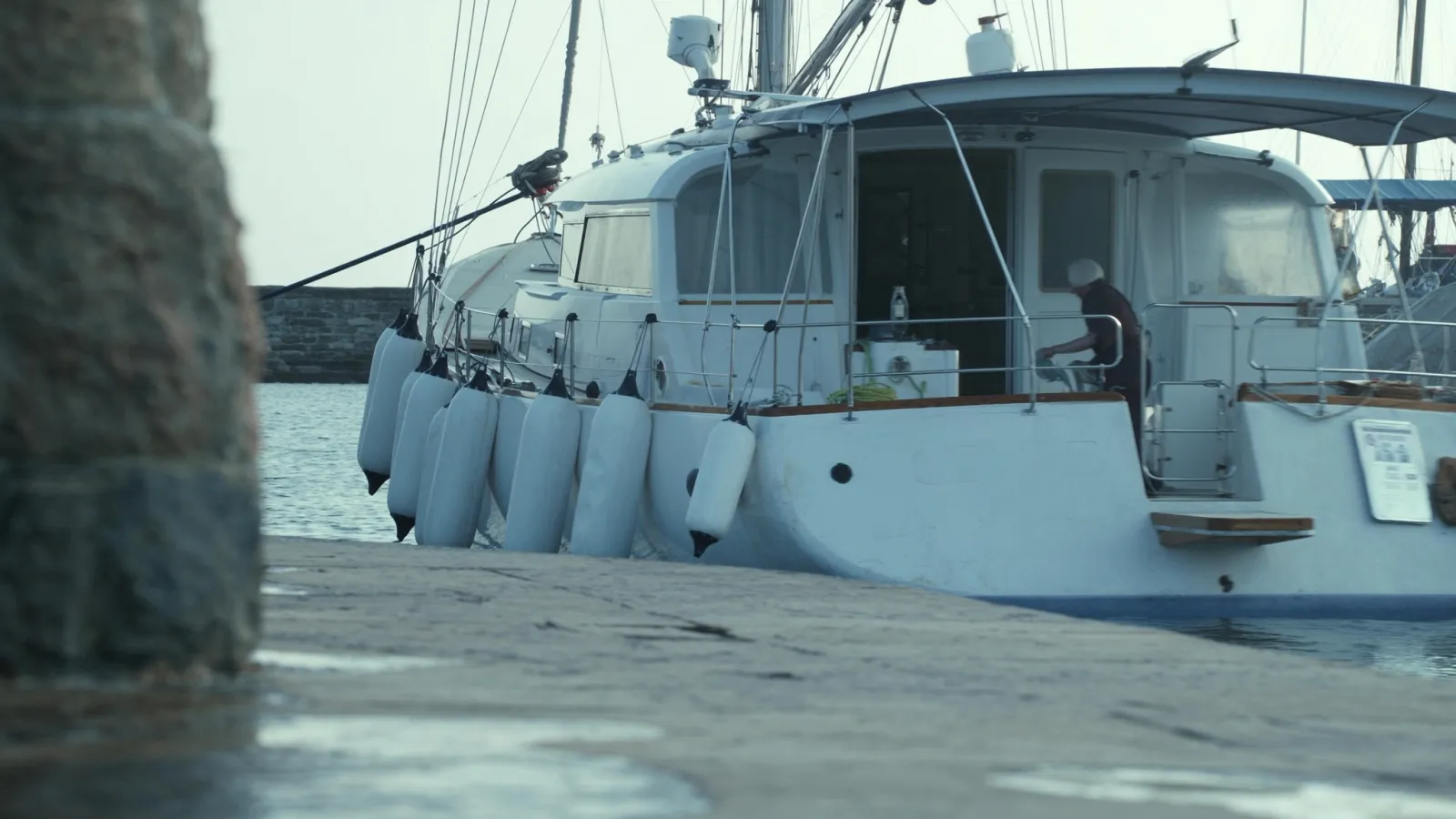 Velero atracado de costado en un muelle con las defensas fuera