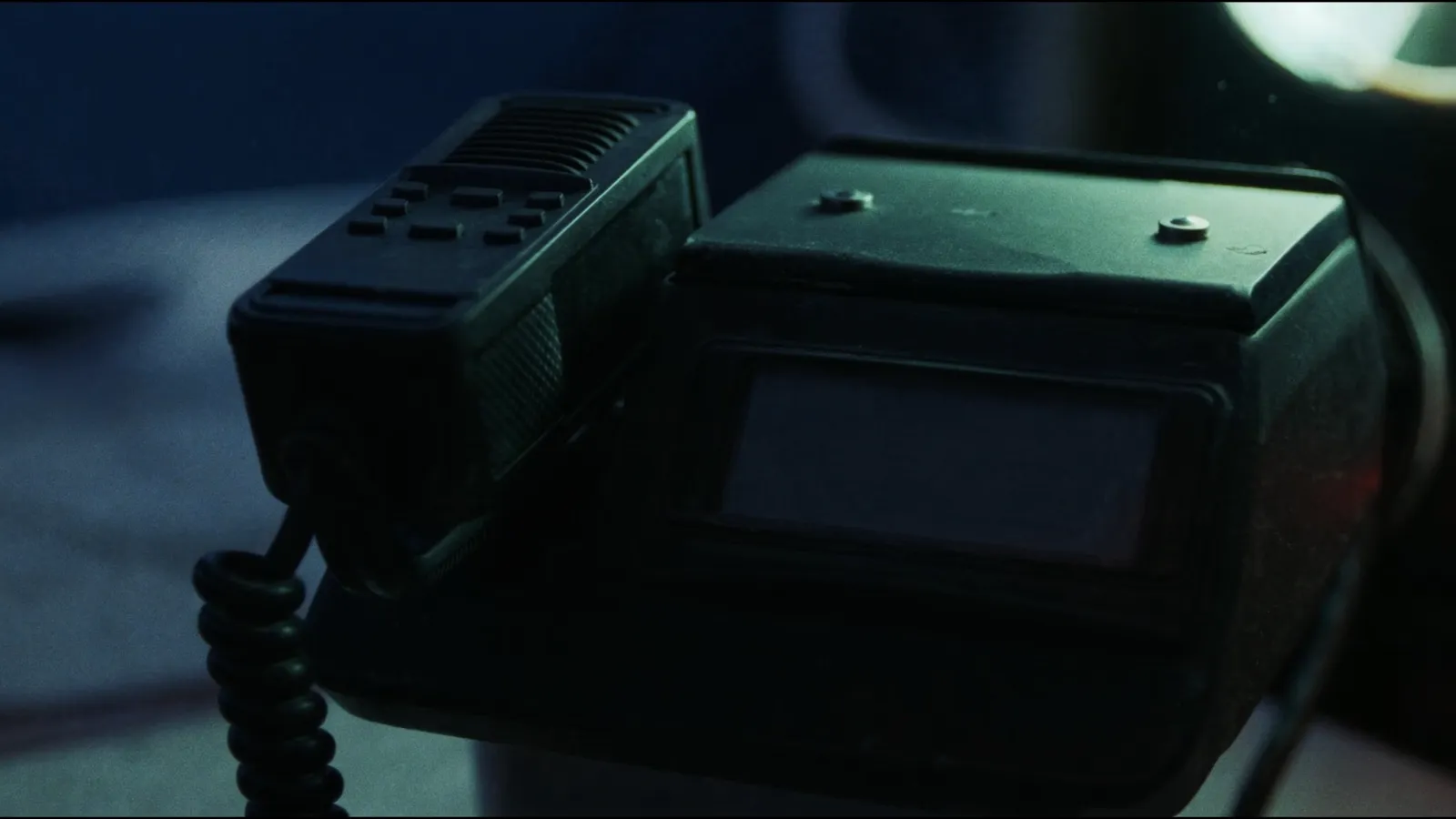 A VHF radio at the chart table of a sailing yacht, handset on its hook