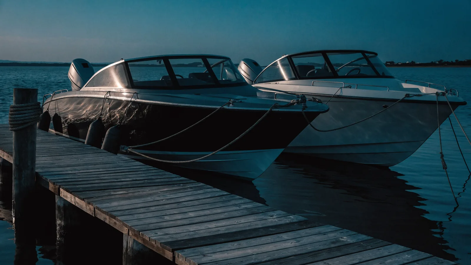 Zwei Boote nebeneinander am Steg, Fender dazwischen