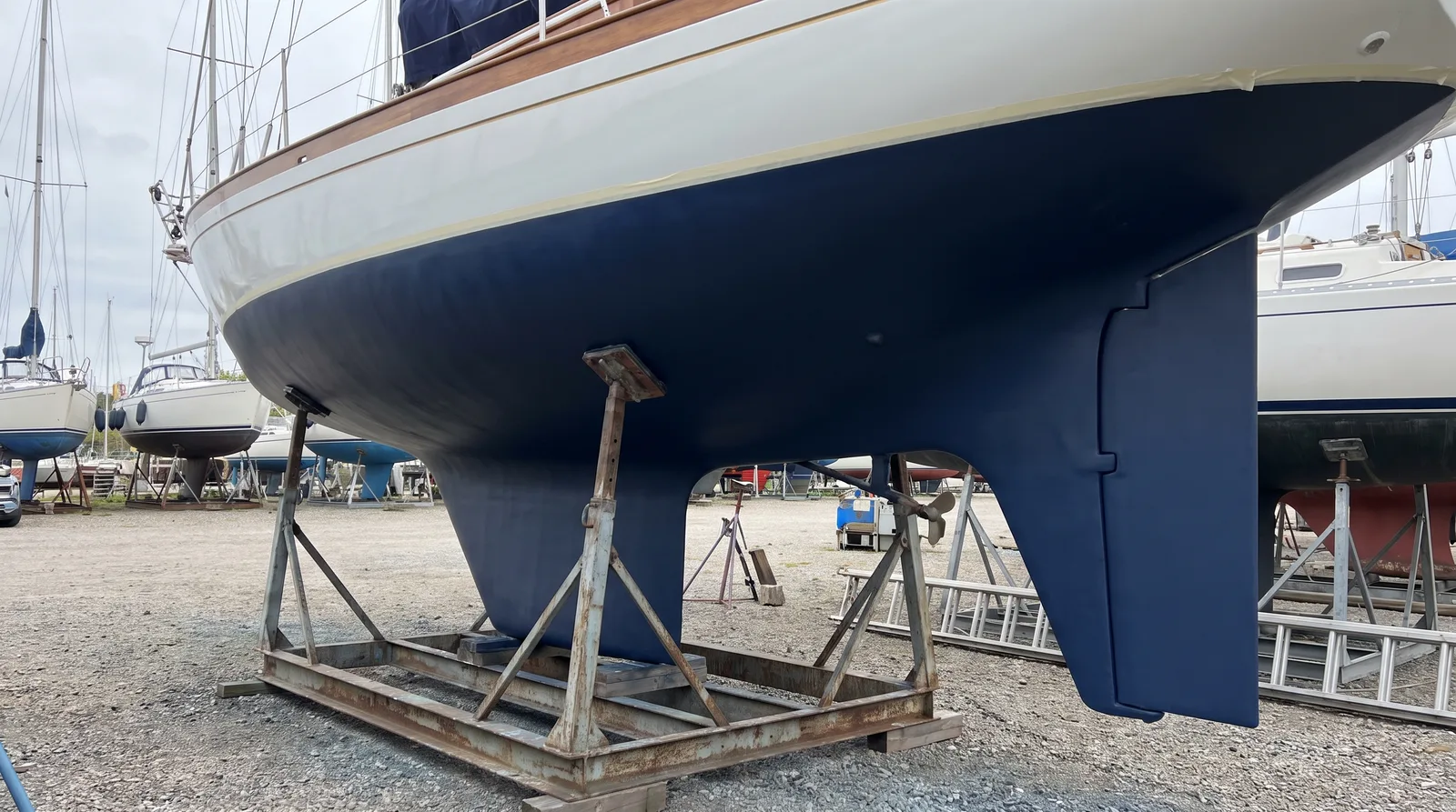 Frisch gestrichenes Unterwasserschiff einer Segelyacht auf dem Lagerbock in der Werft