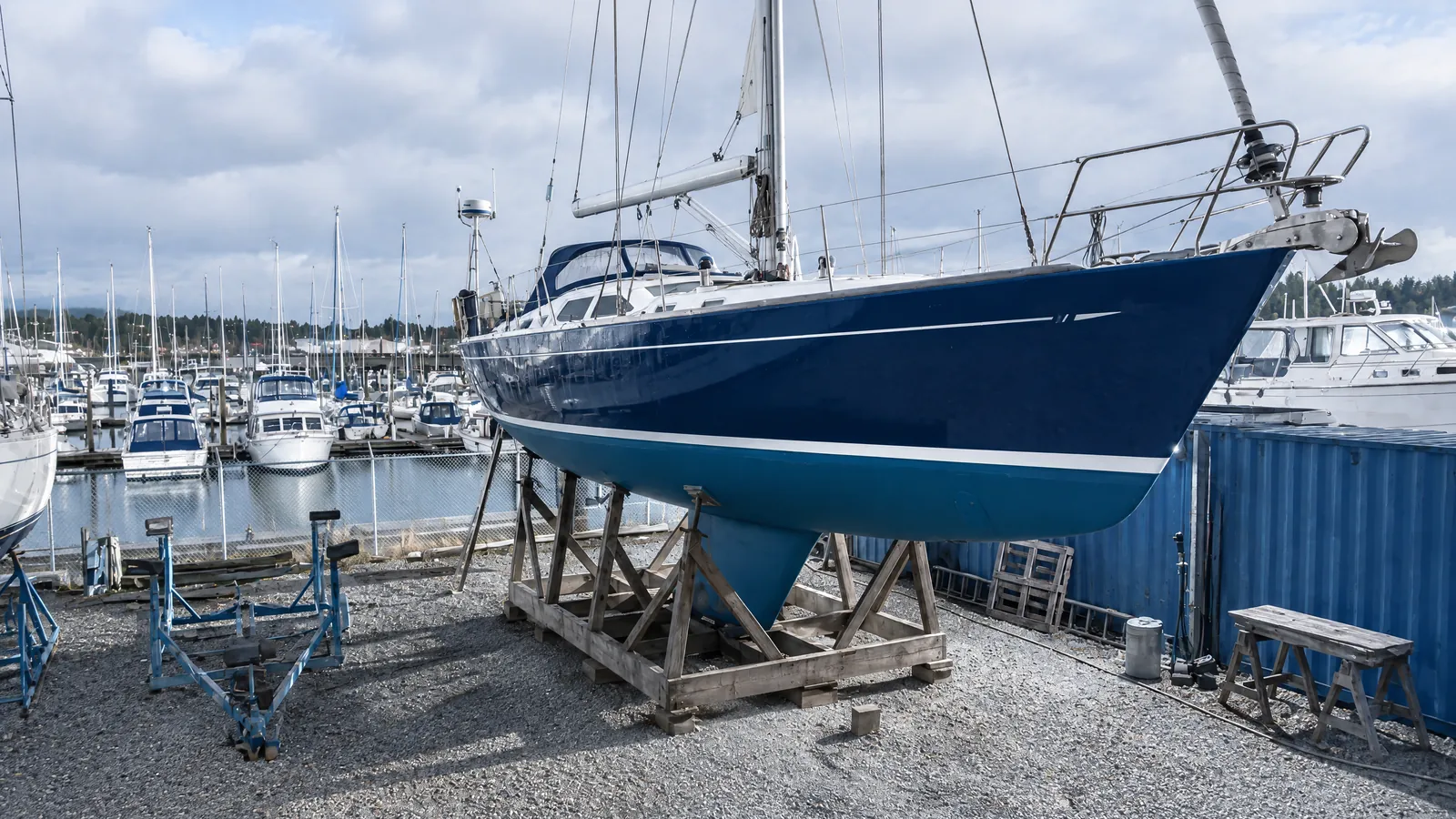 Eine Charteryacht steht im Hochsommer auf dem Bock, während der Hafen dahinter voll ist