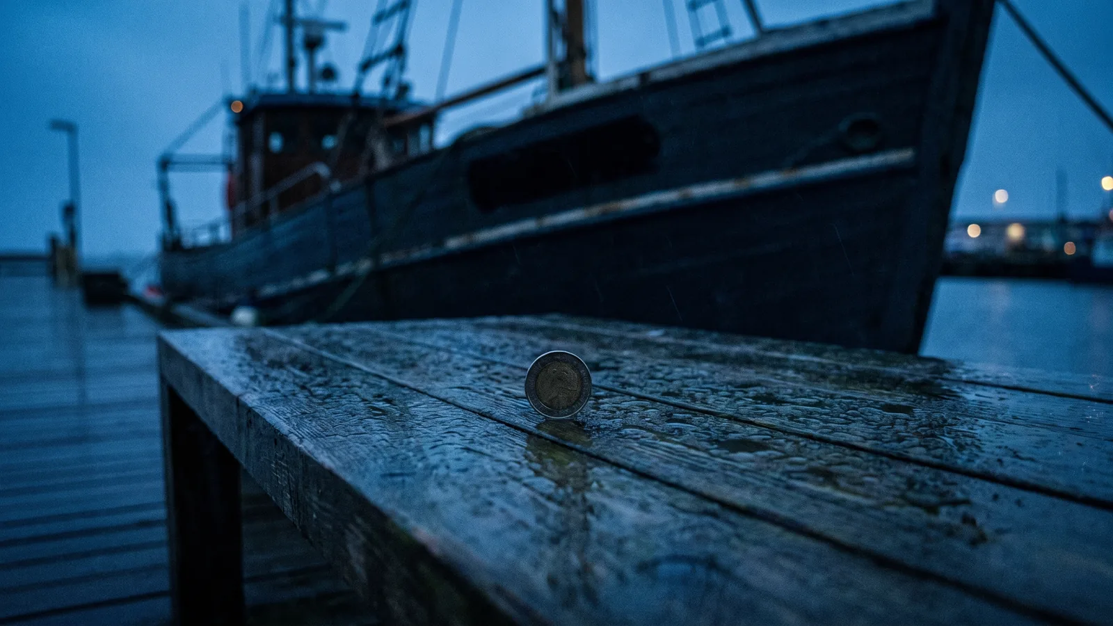 A coin balanced on edge on a wet foredeck as the light goes at the end of the day