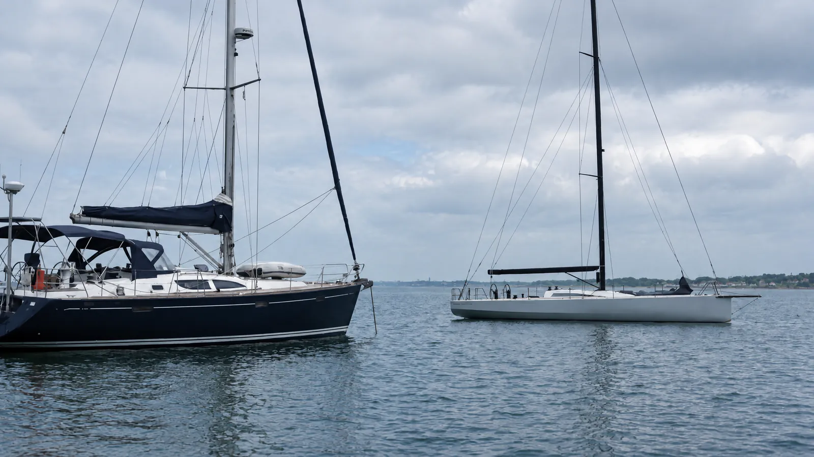 Zwei Boote nebeneinander, eine Fahrtenyacht mit Startnummer und ein nacktes Rennboot