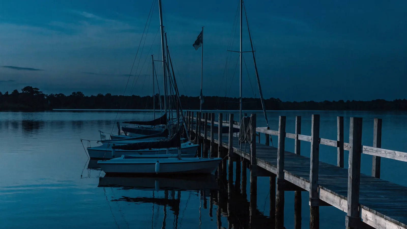Vereinsboote am Steg mit Vereinsstander