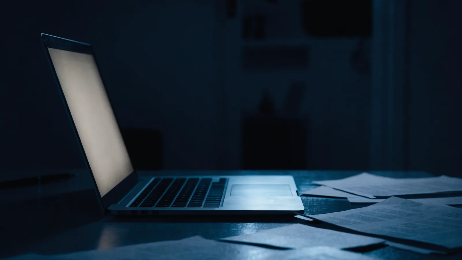 Aufgeklappter Laptop mit leuchtendem Bildschirm im Dunkeln